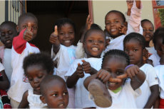 Children smiling and doing a thumbs up